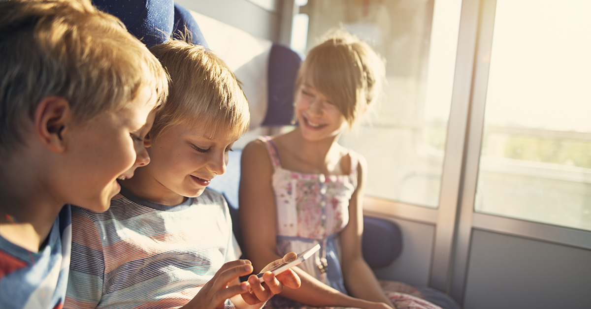 Children seated together on a train. 