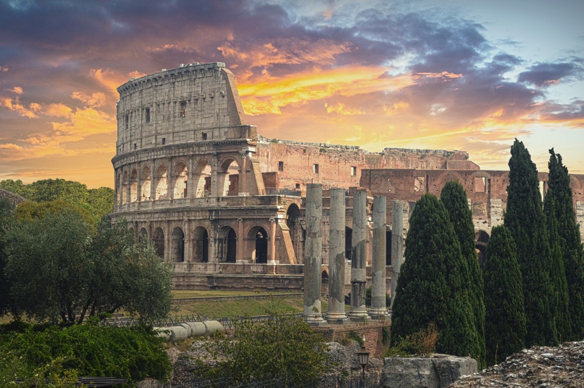 the colosseum at dusk with cyprus trees